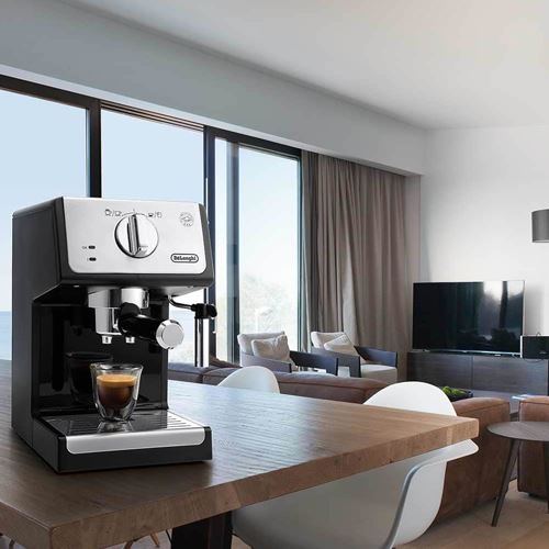 Máquina de espresso en mesa de madera, vaso de café, fondo de sala con vistas.