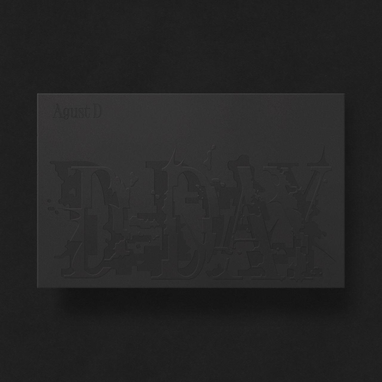 Zwarte vierkante doos met reliëf tekst, met "Agust D" en "D-DAY" in grote letters.