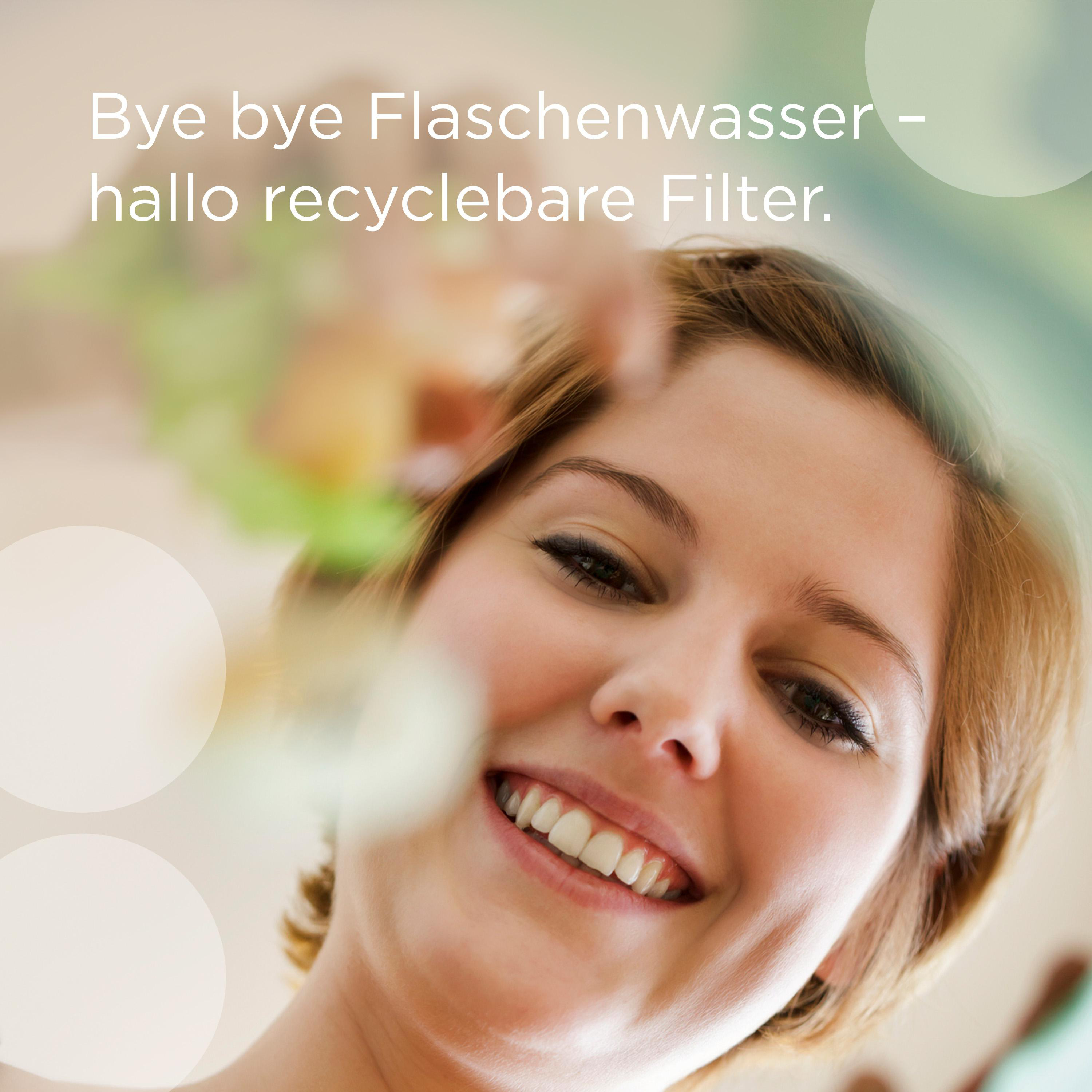 Frau lächelt, blickt nach oben, mit verschwommenem Hintergrund von Blumen.