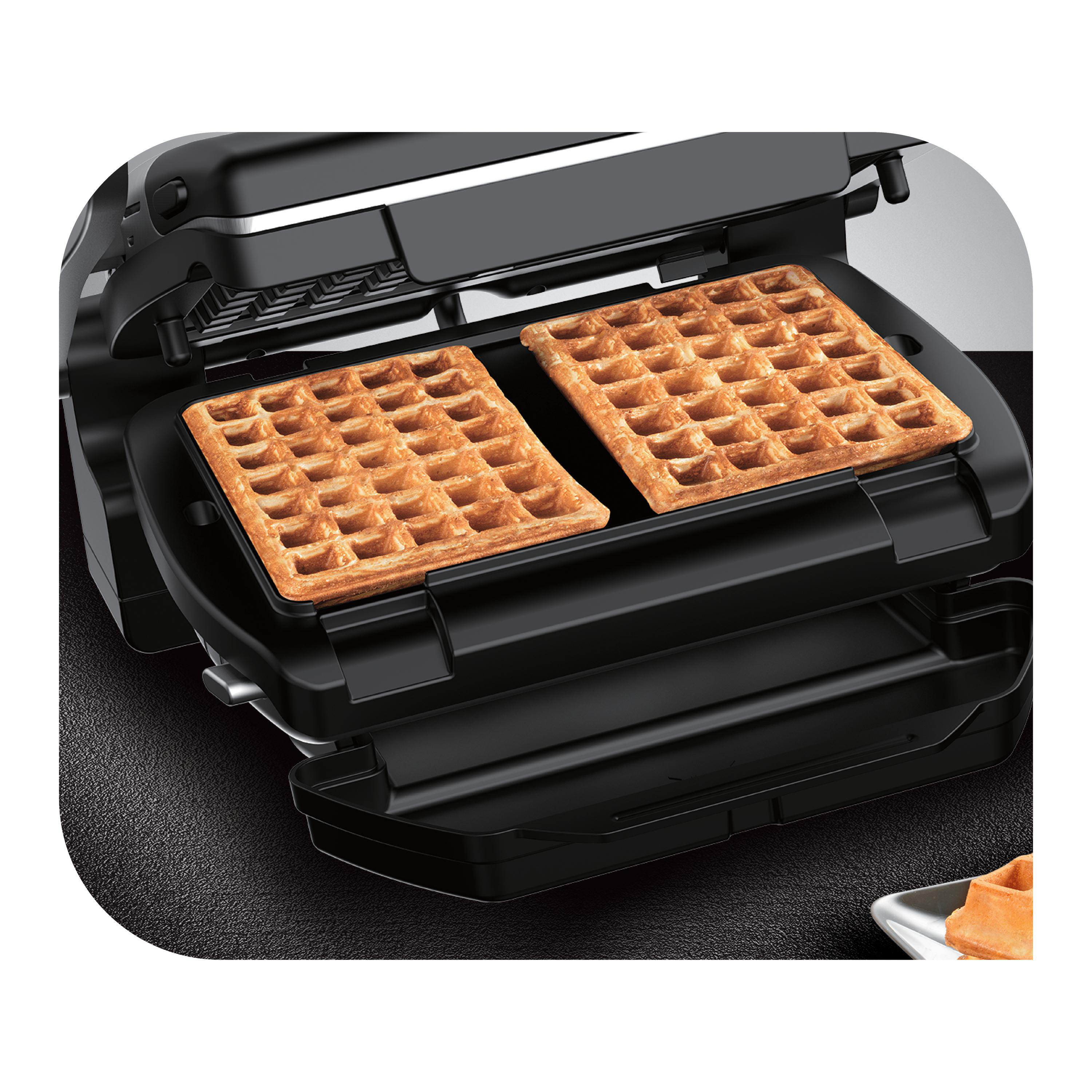Ein schwarzer Waffeleisen geöffnet mit zwei fertigen Waffeln.
