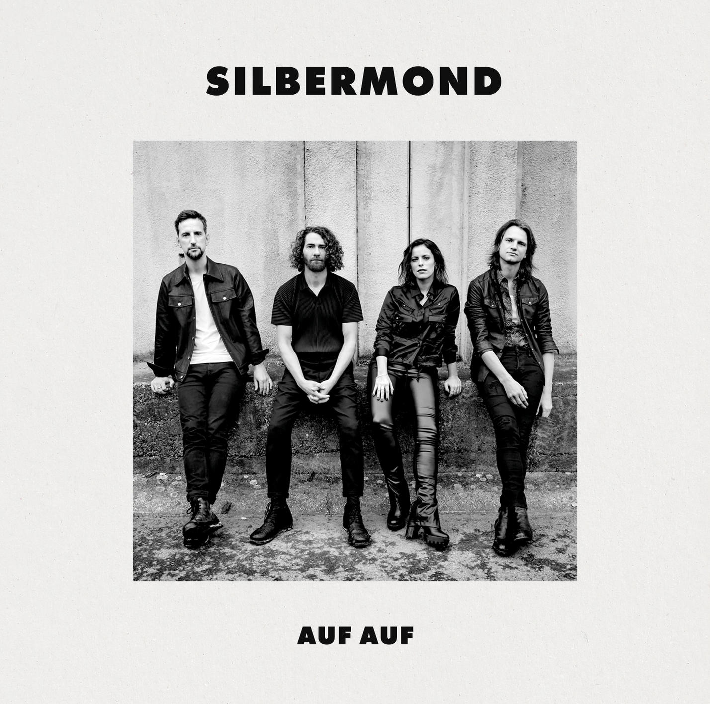 Ein Schwarzweißfoto der Band 'Silbermond', die auf einer Mauer sitzt, mit dem Titel 'AUF AUF'.