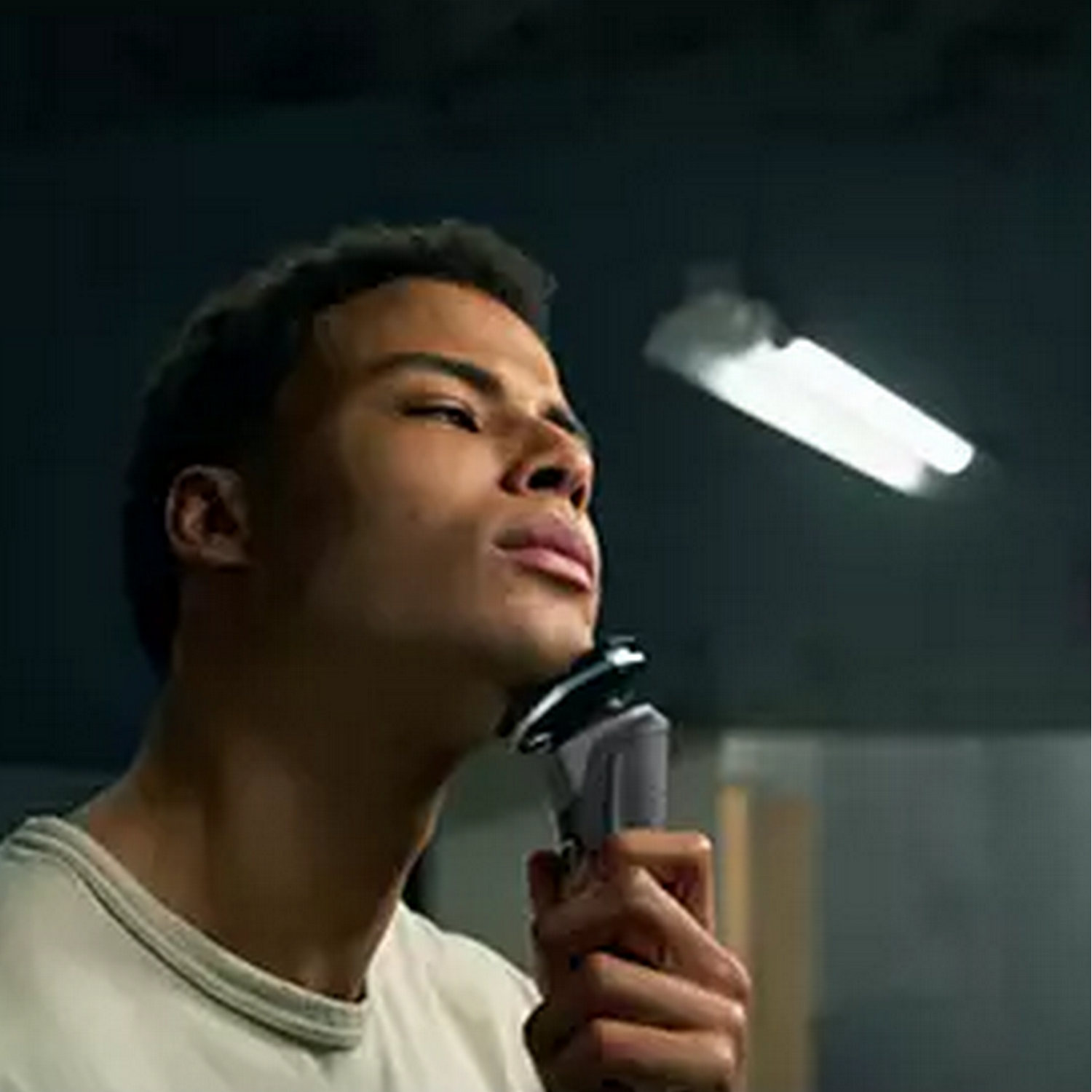 Man shaving his face with an electric razor.