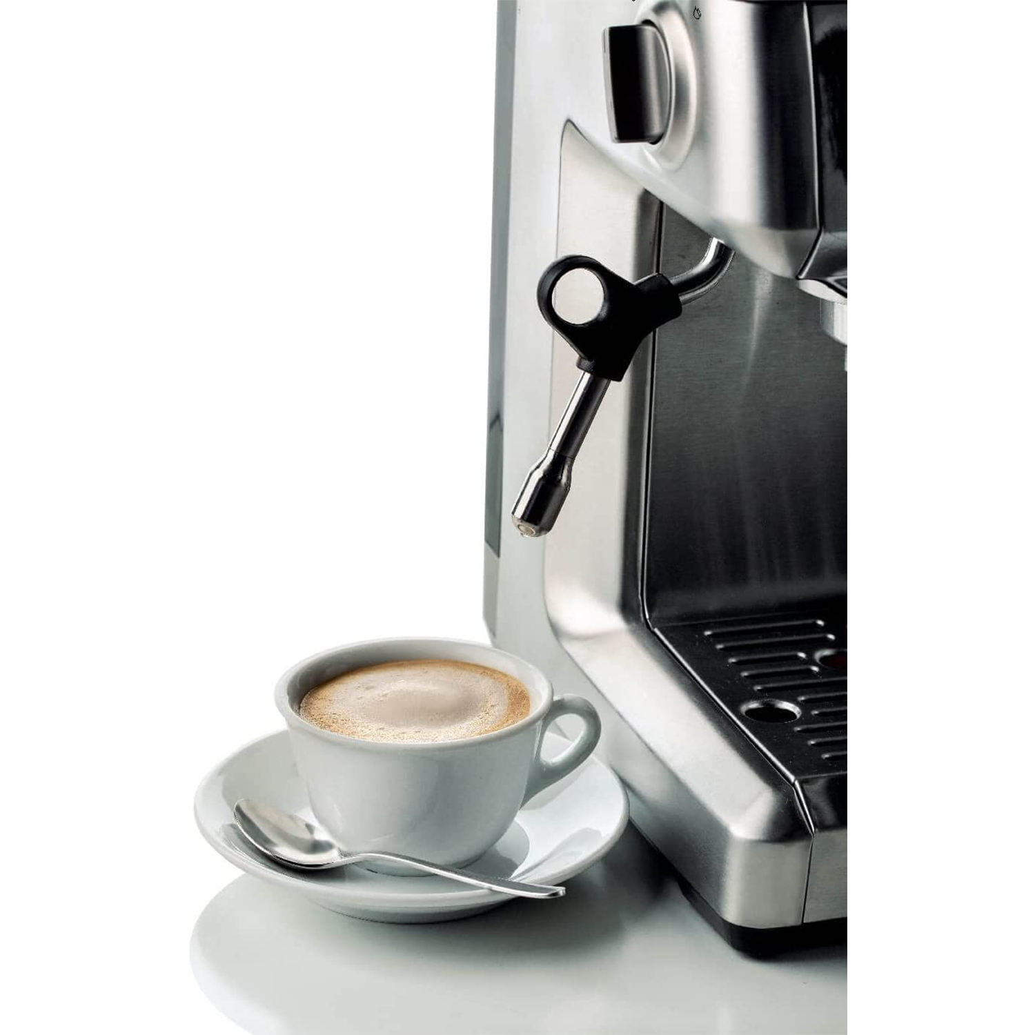 Una macchina da caffè con una tazza di caffè, piattino e cucchiaio, su sfondo bianco.