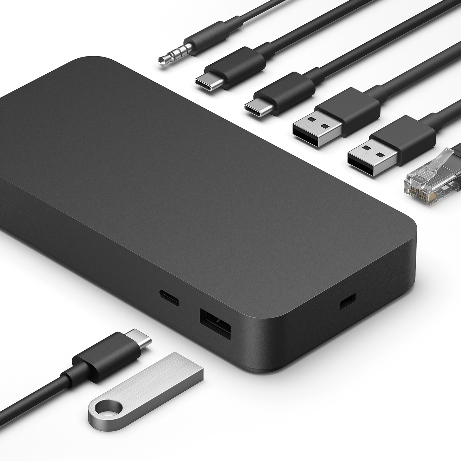 Un hub nero con vari cavi tra cui USB-C, USB, ethernet e un'unità USB, su una superficie bianca.