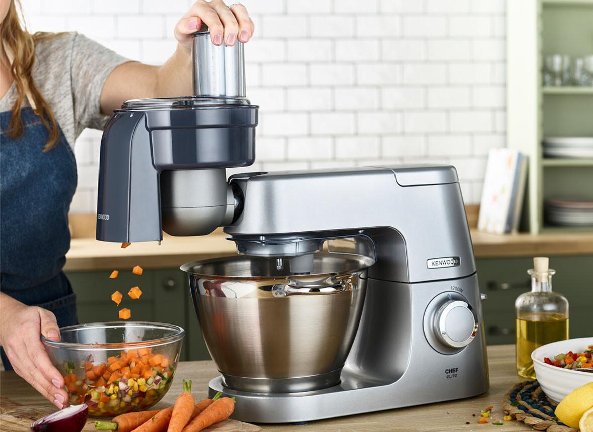 Eine Frau benutzt einen Kenwood Chef Mixer mit einem Küchenmaschinenaufsatz.