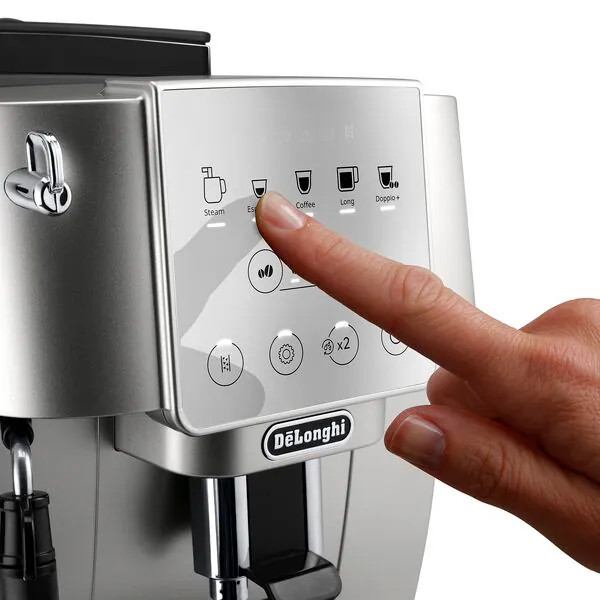 A hand pressing the 'Espresso' button on a silver De'Longhi coffee machine.