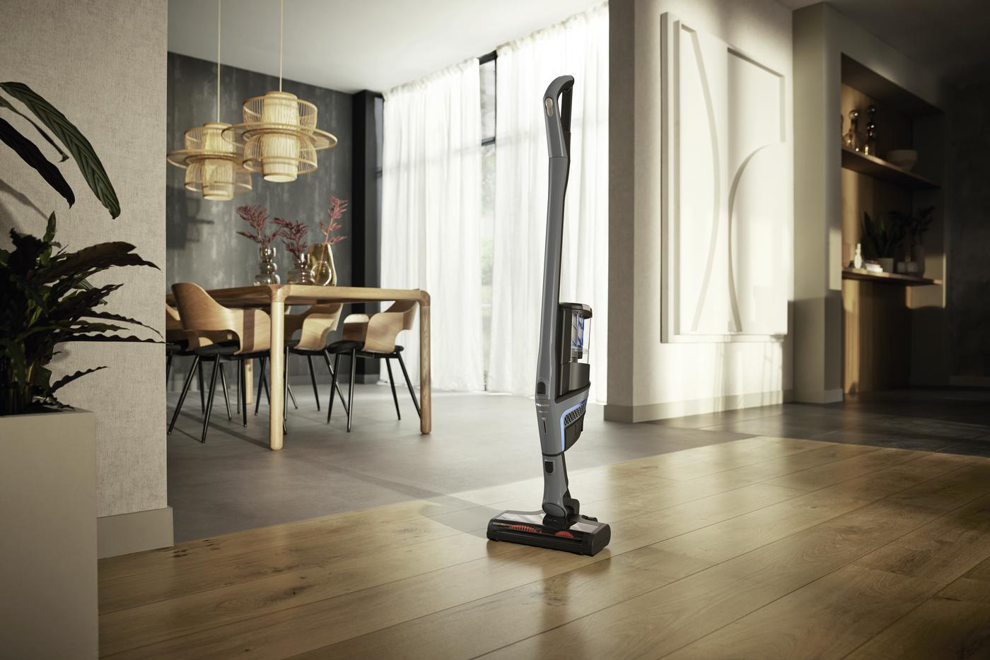 Ein kabelloser Staubsauger steht auf einem Holzboden in einem modernen Wohnzimmer.