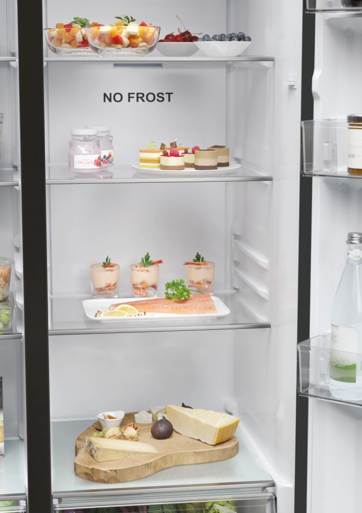 Interno del frigorifero con ripiani contenenti cibo e dessert.