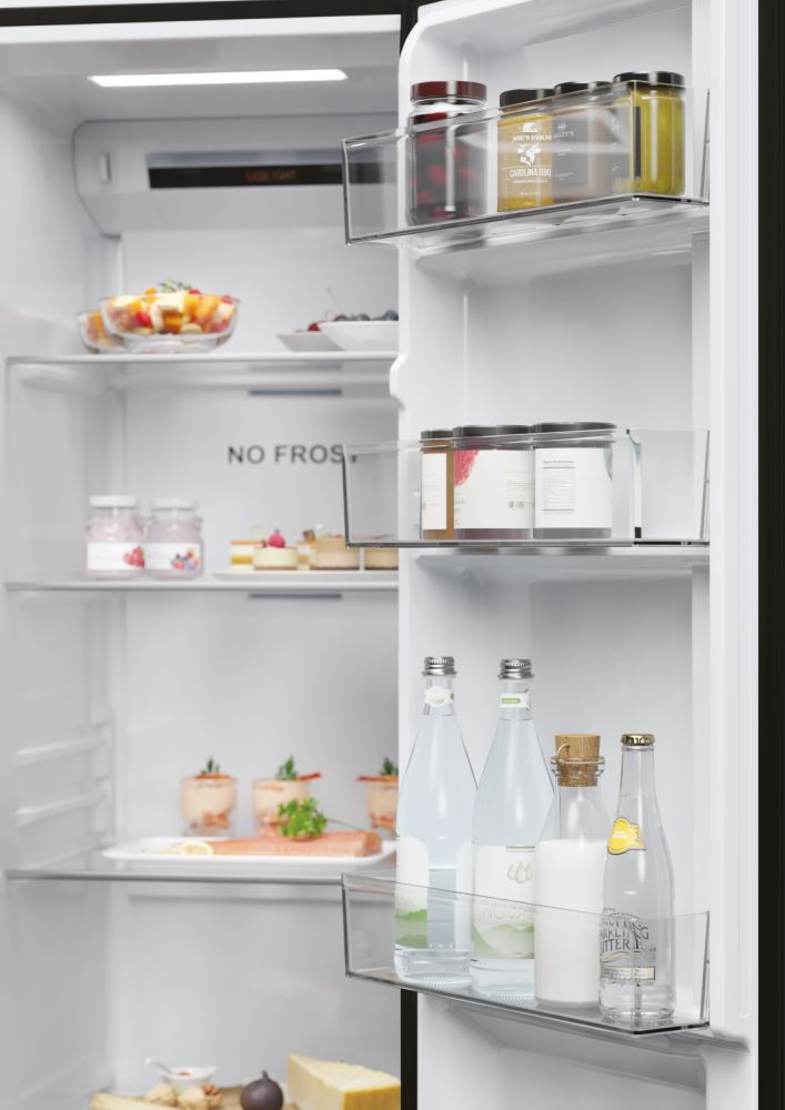 Frigorifero aperto con cibo: frutta, barattoli, bottiglie d'acqua e formaggio. Vista interna.