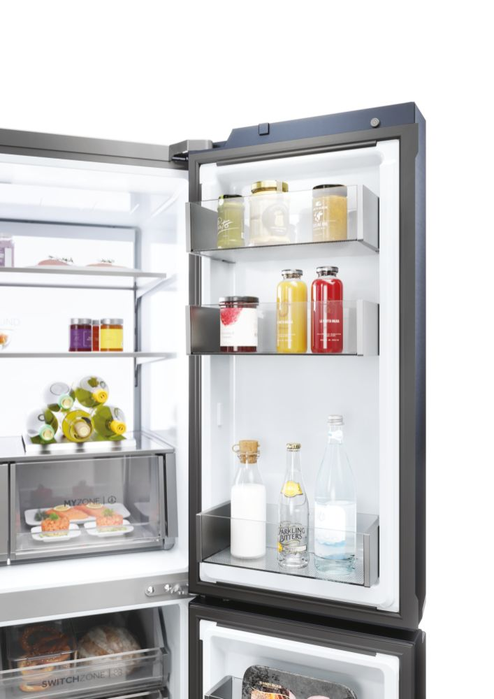 Kühlschrank-Innenraum mit Lebensmitteln und Getränken gefüllt. Gläser, Flaschen und Behälter sind sichtbar.