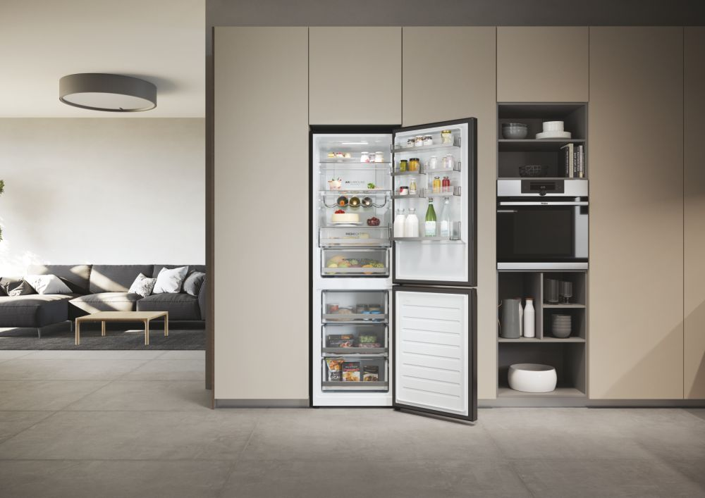 Frigorifero aperto in una cucina moderna con mobili beige.