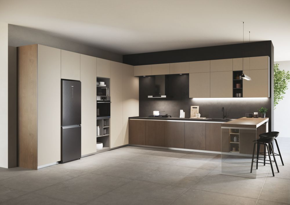 Una cucina moderna con mobili beige e un piano di lavoro scuro. C'è un frigorifero e un'isola.