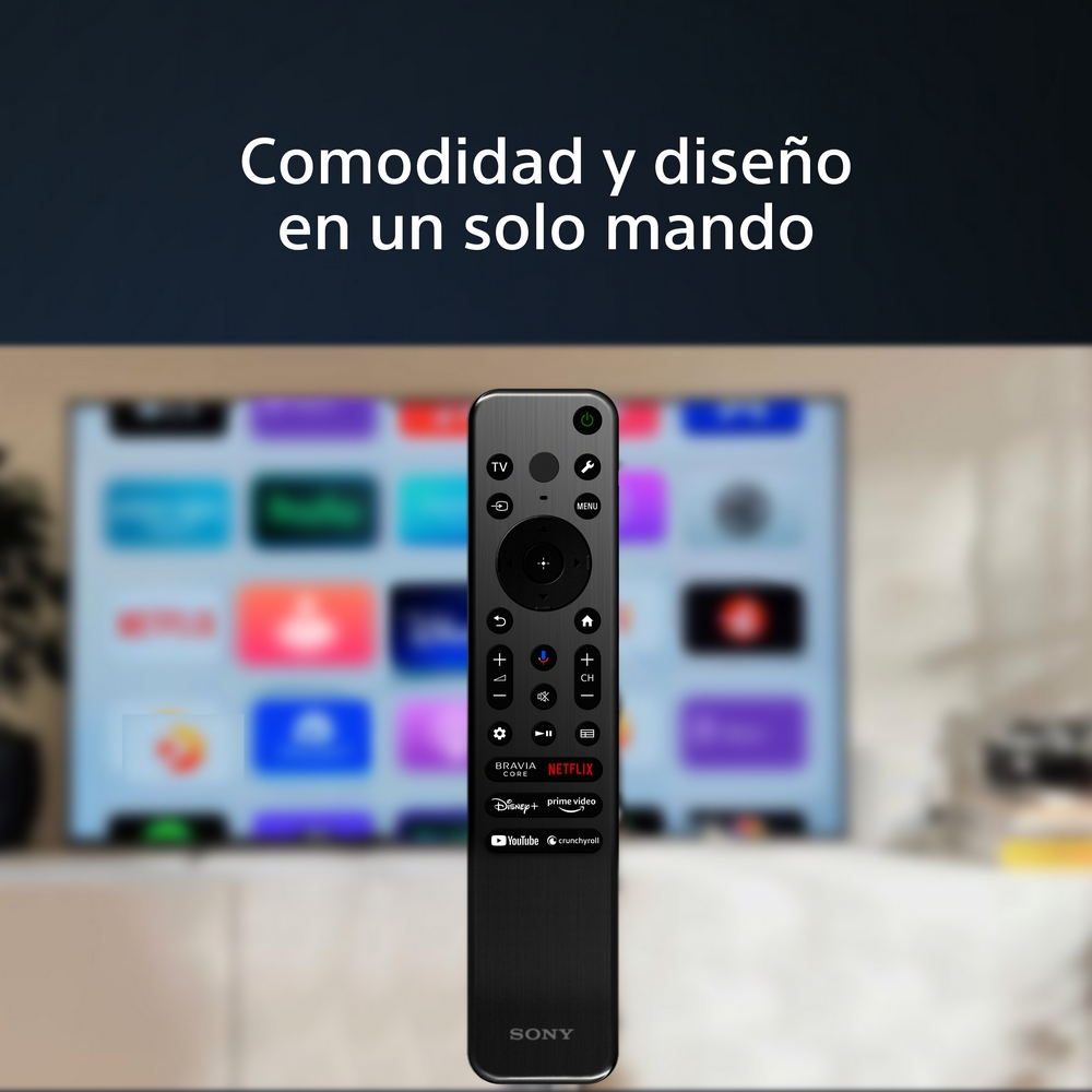 Un mando a distancia negro con muchos botones frente a una pantalla de TV que muestra una interfaz colorida.