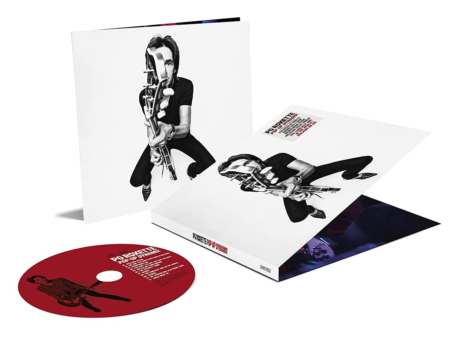 Pop-Up Dynamite CD szett. CD, album borító és gitáros zenekari tag látható.