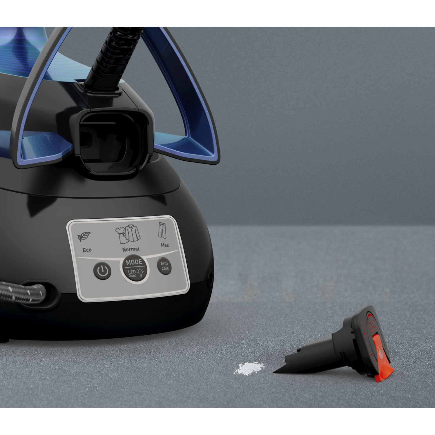 Black and blue steam iron. Mode options shown. Detached nozzle and white residue on gray surface.
