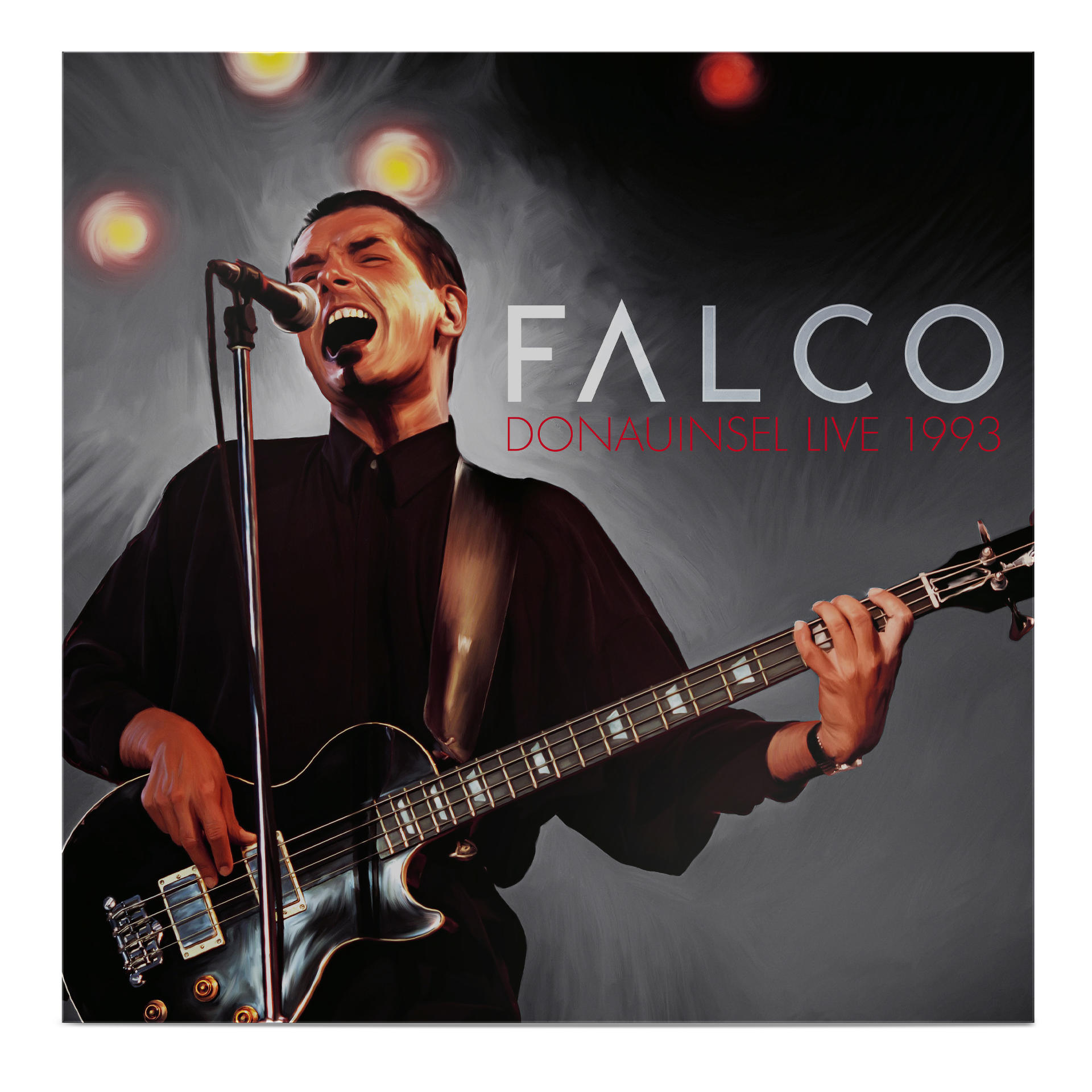 Falco auf der Bühne singt und spielt einen schwarzen Bassgitarre. Der Hintergrund ist mit Lichtern und Rauch verschwommen.