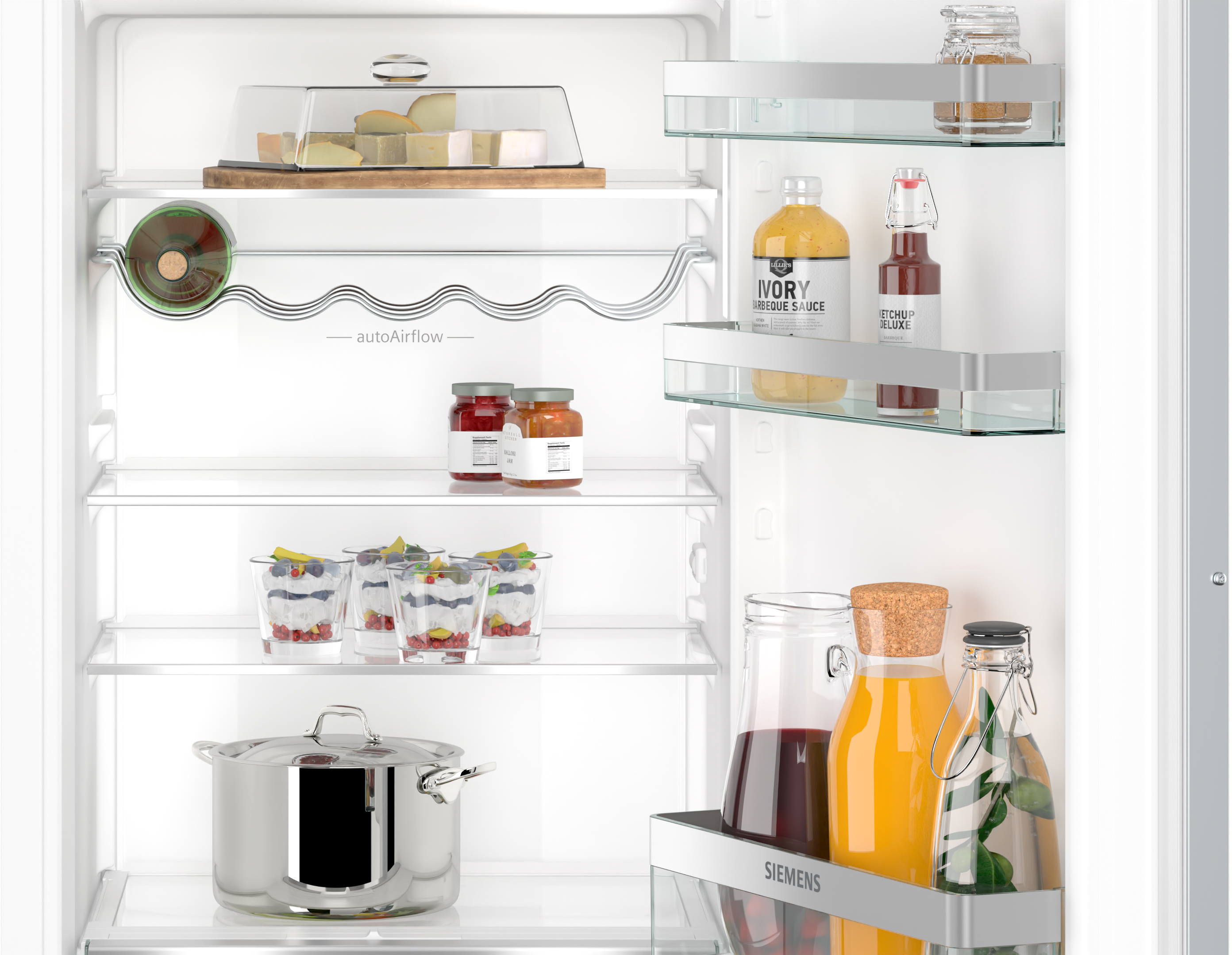 Offener Kühlschrank mit Regalen. Lebensmittel sind Käse, Soßen und Getränke. Der Kühlschrank ist sauber.