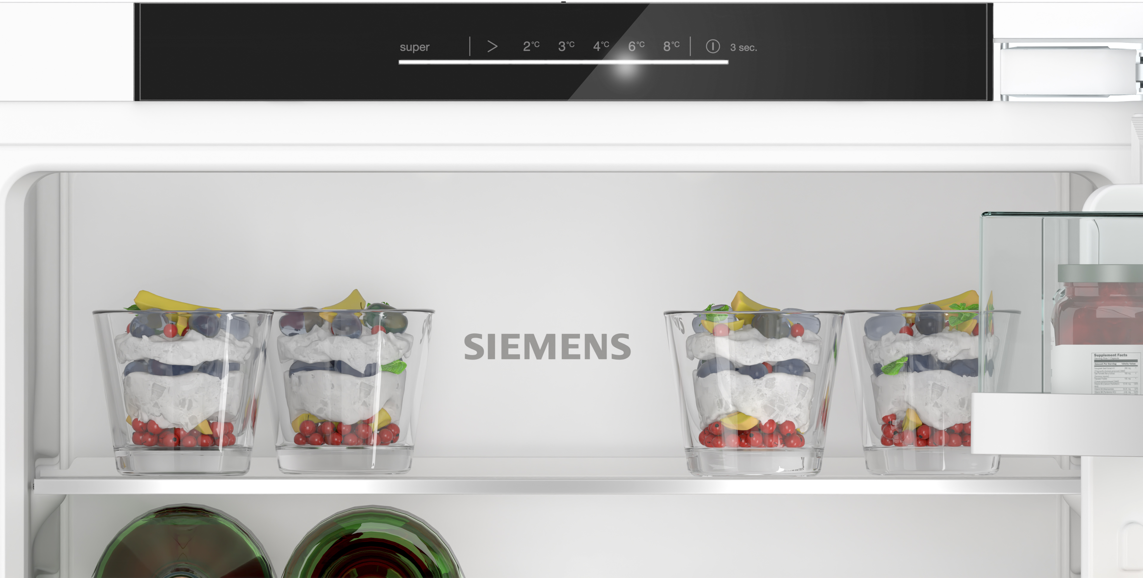 Ein Kühlschrank mit vier Glasschalen. Jede Schale enthält ein geschichtetes Dessert.