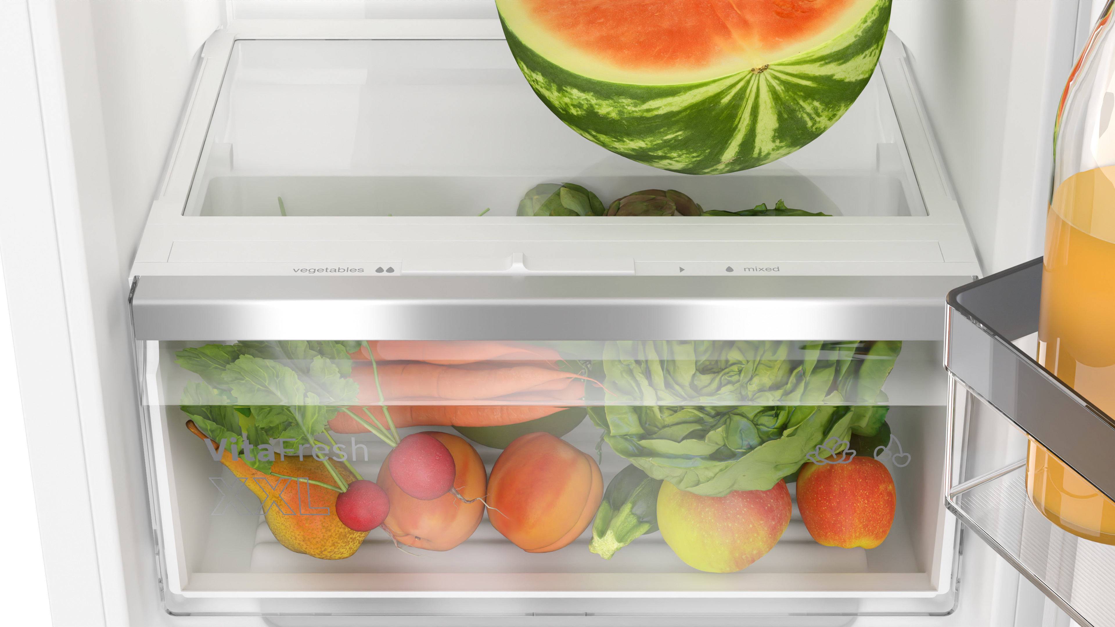Kühlschublade mit Obst und Gemüse, darunter Wassermelone und Karotten.