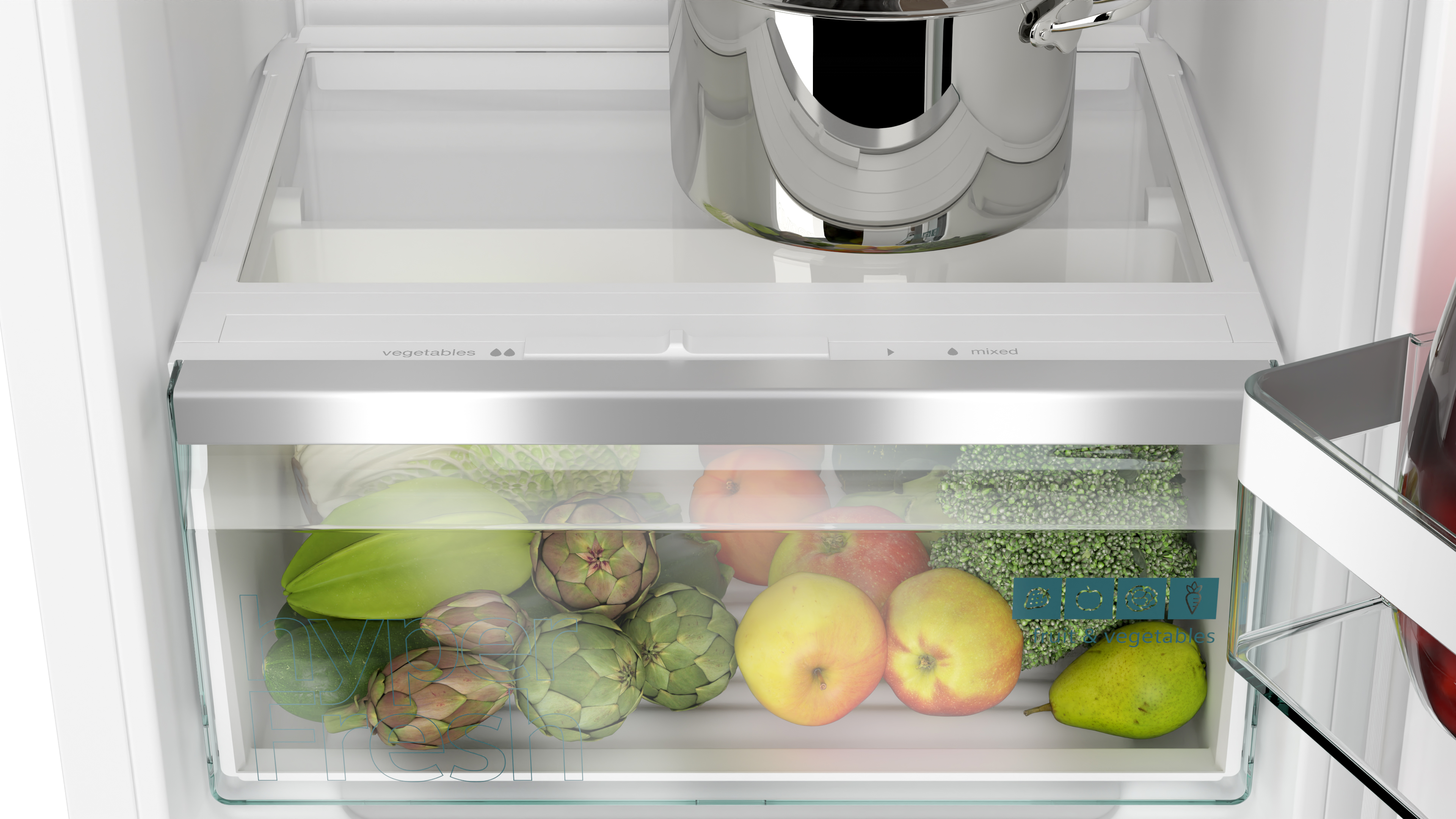 Koelkastinterieur. Groentelade met artisjokken, appels en meer. Een pot staat erboven.