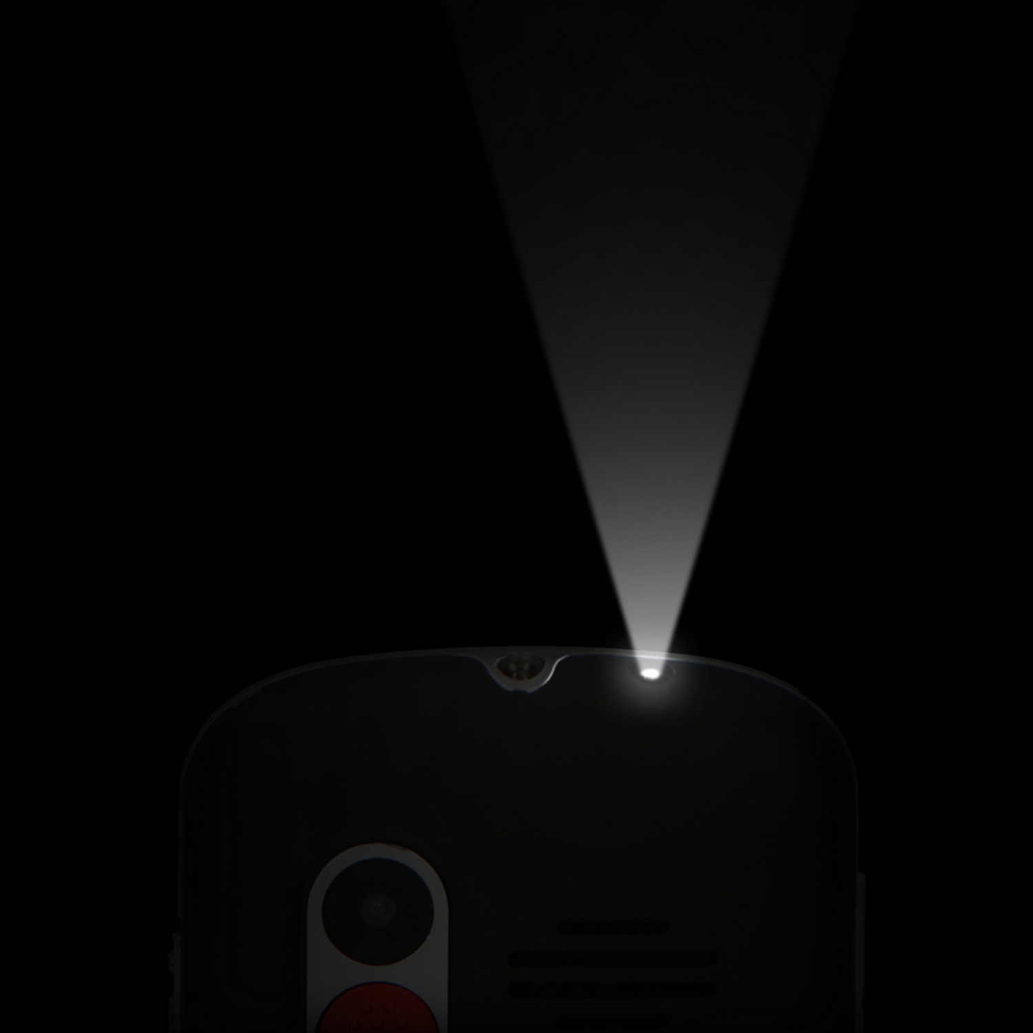 A phone's top, illuminated by a spotlight from above, against a black backdrop.