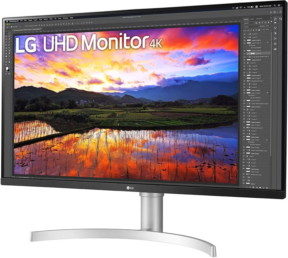 Un moniteur LG 4K affiche un coucher de soleil vibrant sur un paysage avec des montagnes et un plan d'eau réfléchissant.