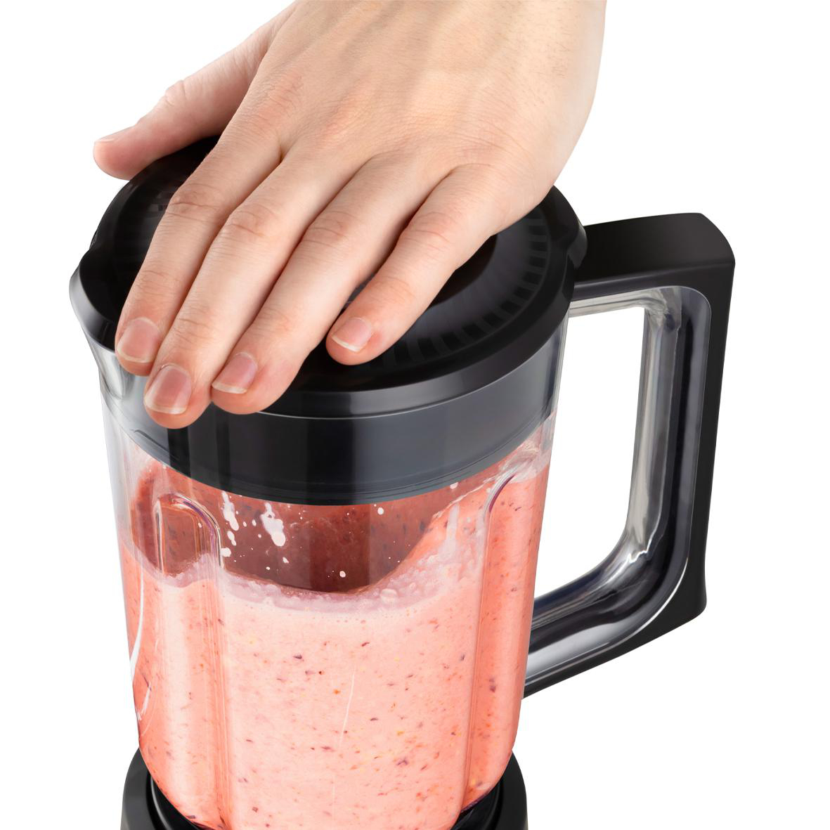 Hand hält den Deckel eines Mixers, der mit einer rosa Mischung gefüllt ist. Der Mixer ist schwarz und weiß.
