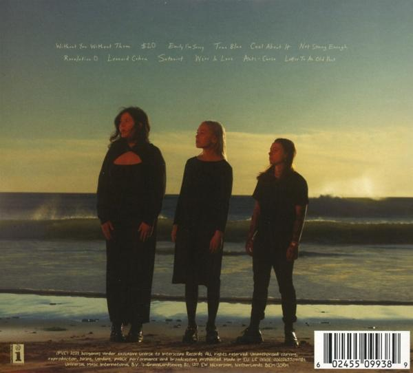 Drei Frauen stehen am Strand und blicken aufs Meer. Albumcover mit Titeln.