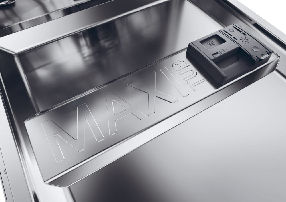 Interno lavastoviglie in acciaio inox. Visibile la scritta MAXI TUB. Un dispenser di sapone nero a destra.