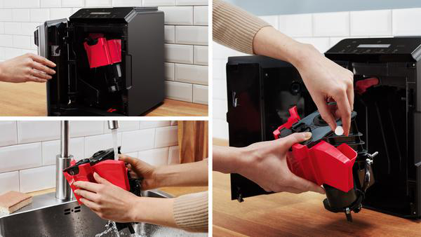 Eine Person reinigt eine Kaffeemaschine. Rote Teile werden entfernt und unter einem Wasserhahn gewaschen. Eine Tablette wird in ein Teil gelegt.