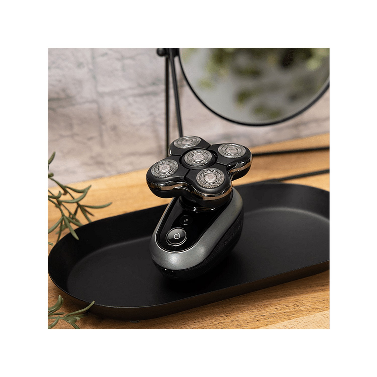 Electric shaver on a black tray, with a mirror. The shaver has five heads.