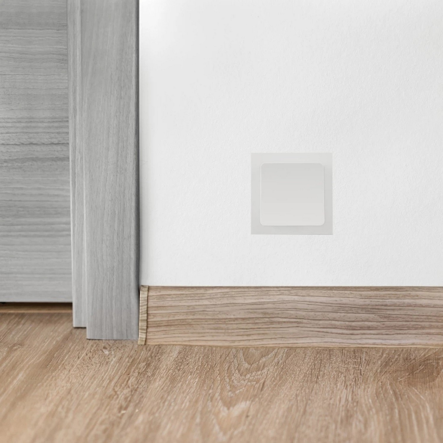 A white wall-mounted smart switch with a square shape.