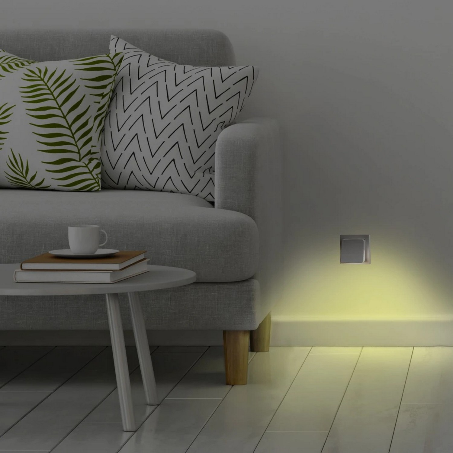 A sofa with pillows, a side table, and a wall socket with a yellow light.