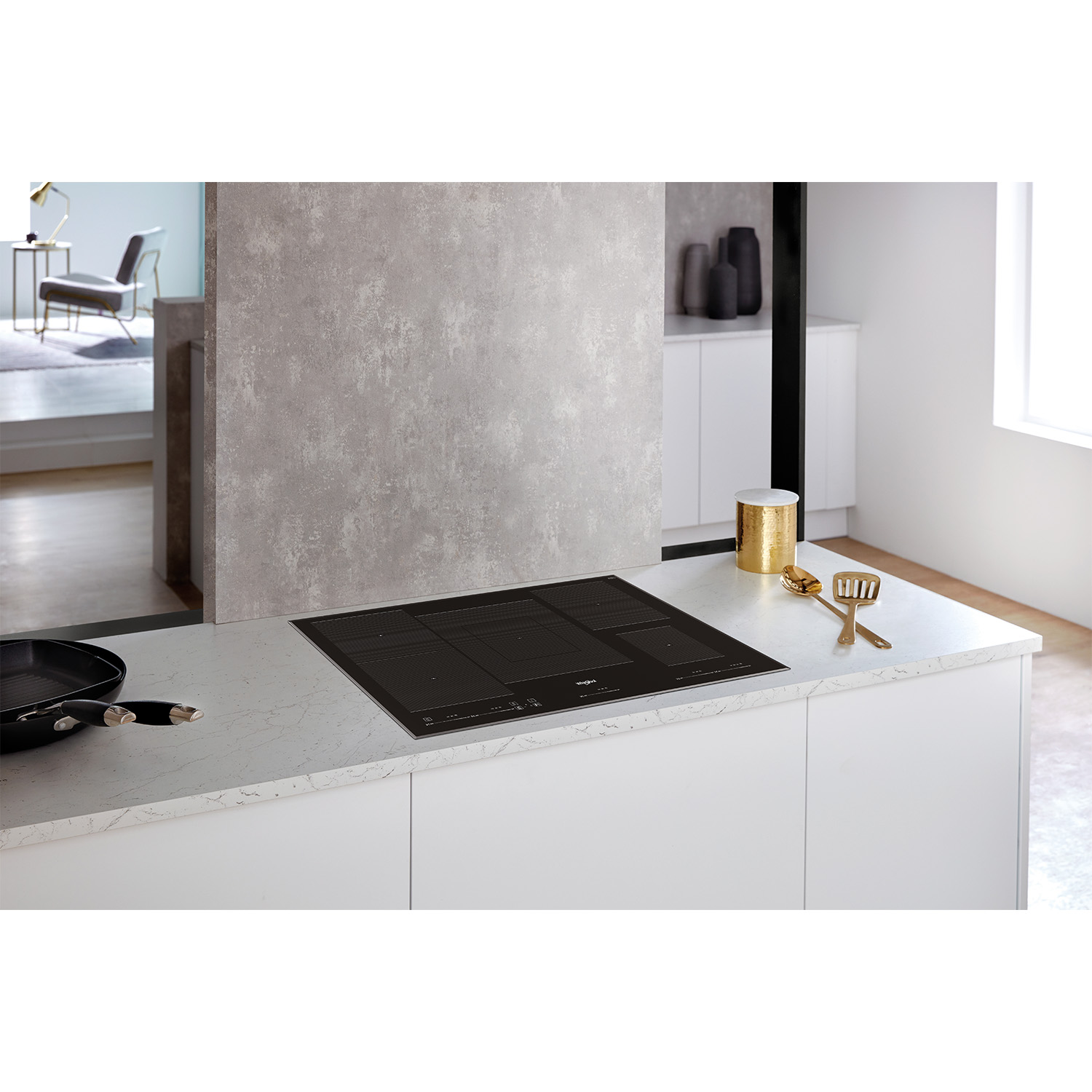 Cucina moderna con piano cottura a induzione. Pentole e decorazioni visibili.