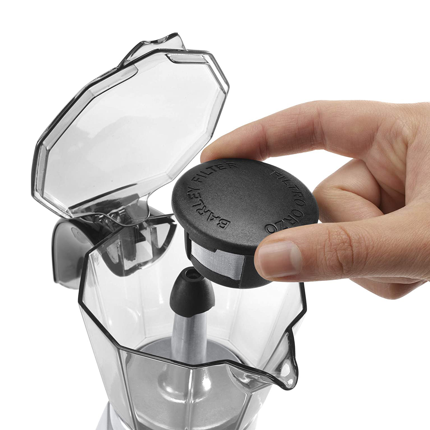 Una mano inserisce un filtro nero in una caffettiera trasparente.