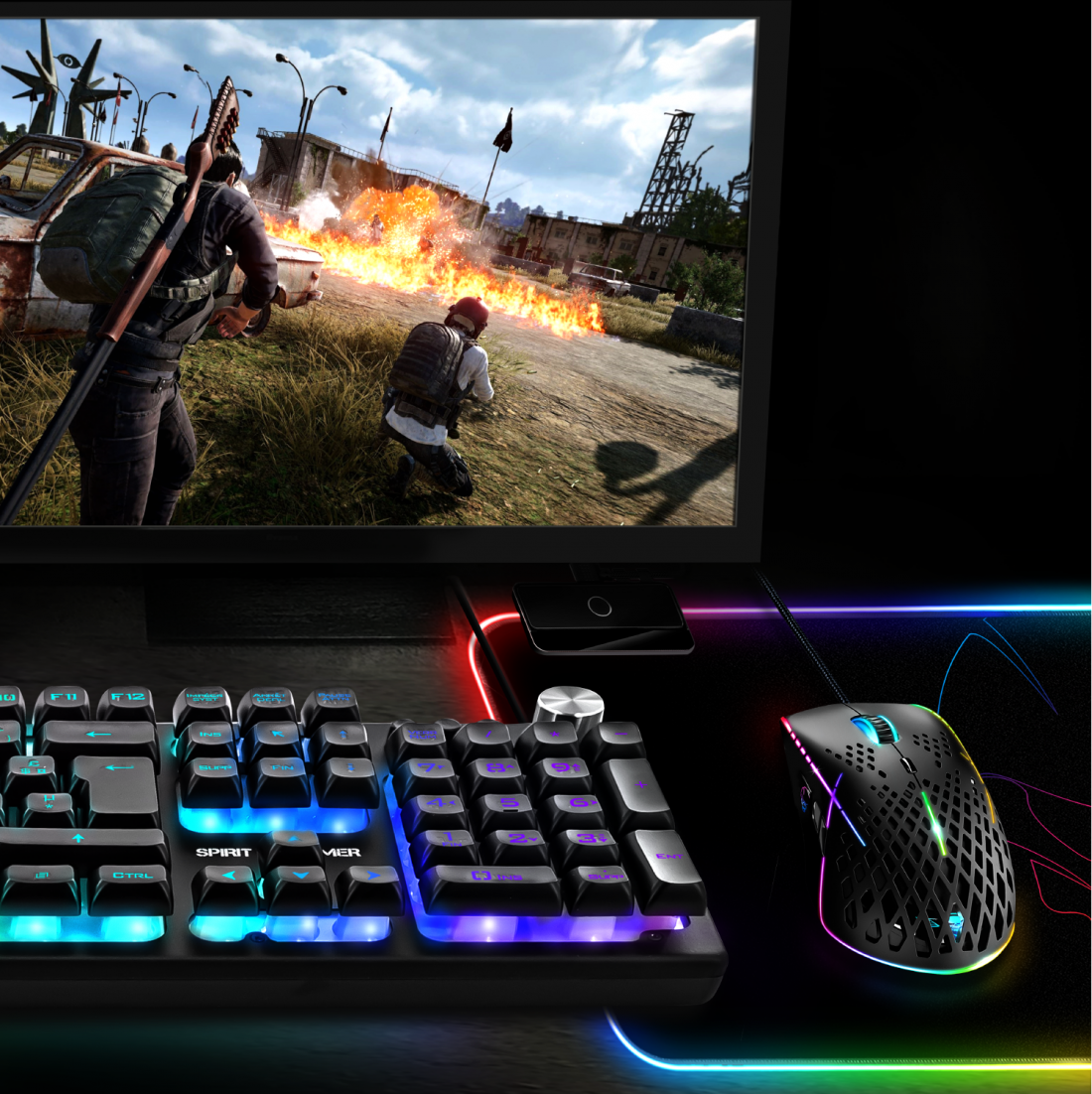 Gaming setup: billentyűzet, egér, monitor robbanásokkal.