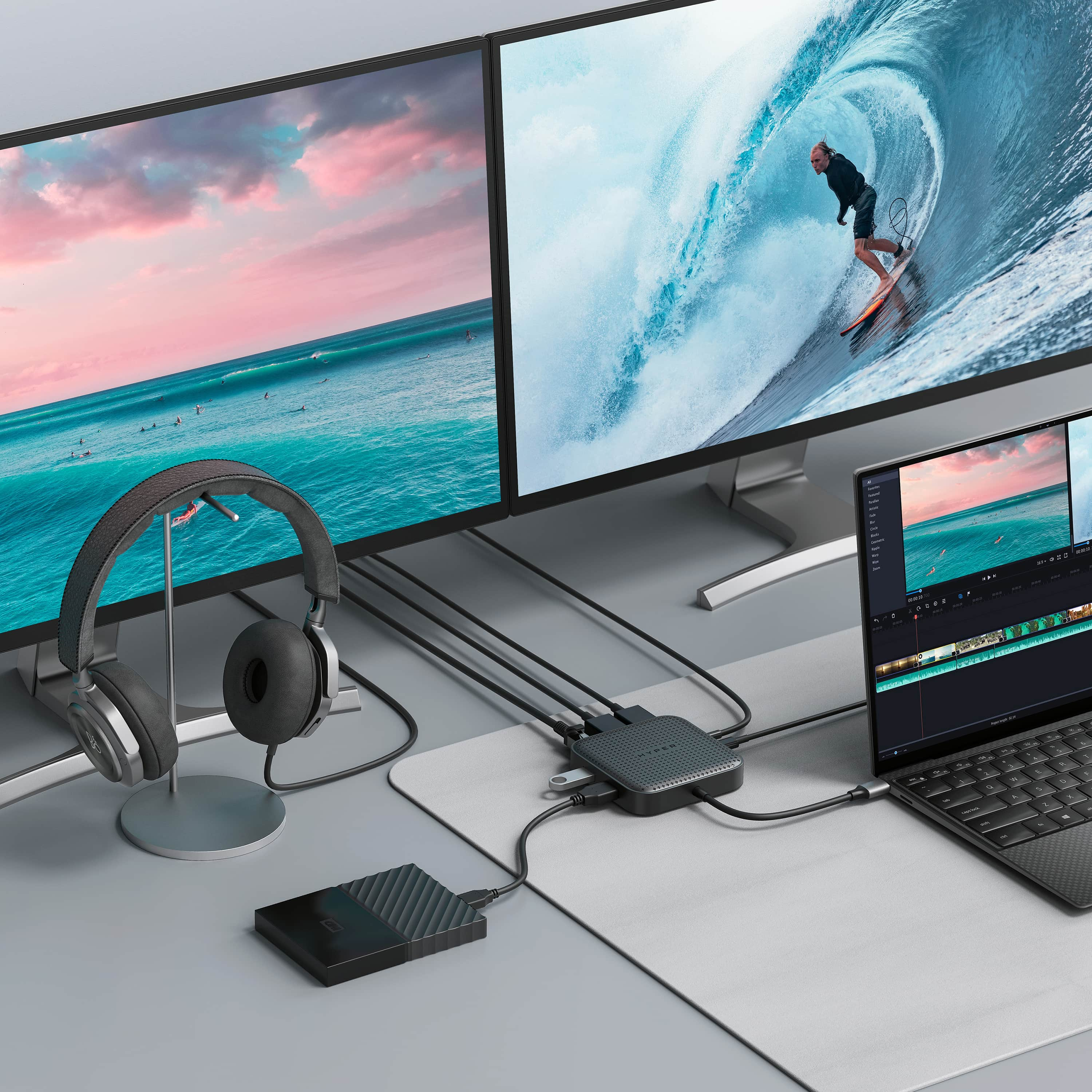 Dos monitores, portátil, auriculares y un hub en un escritorio.