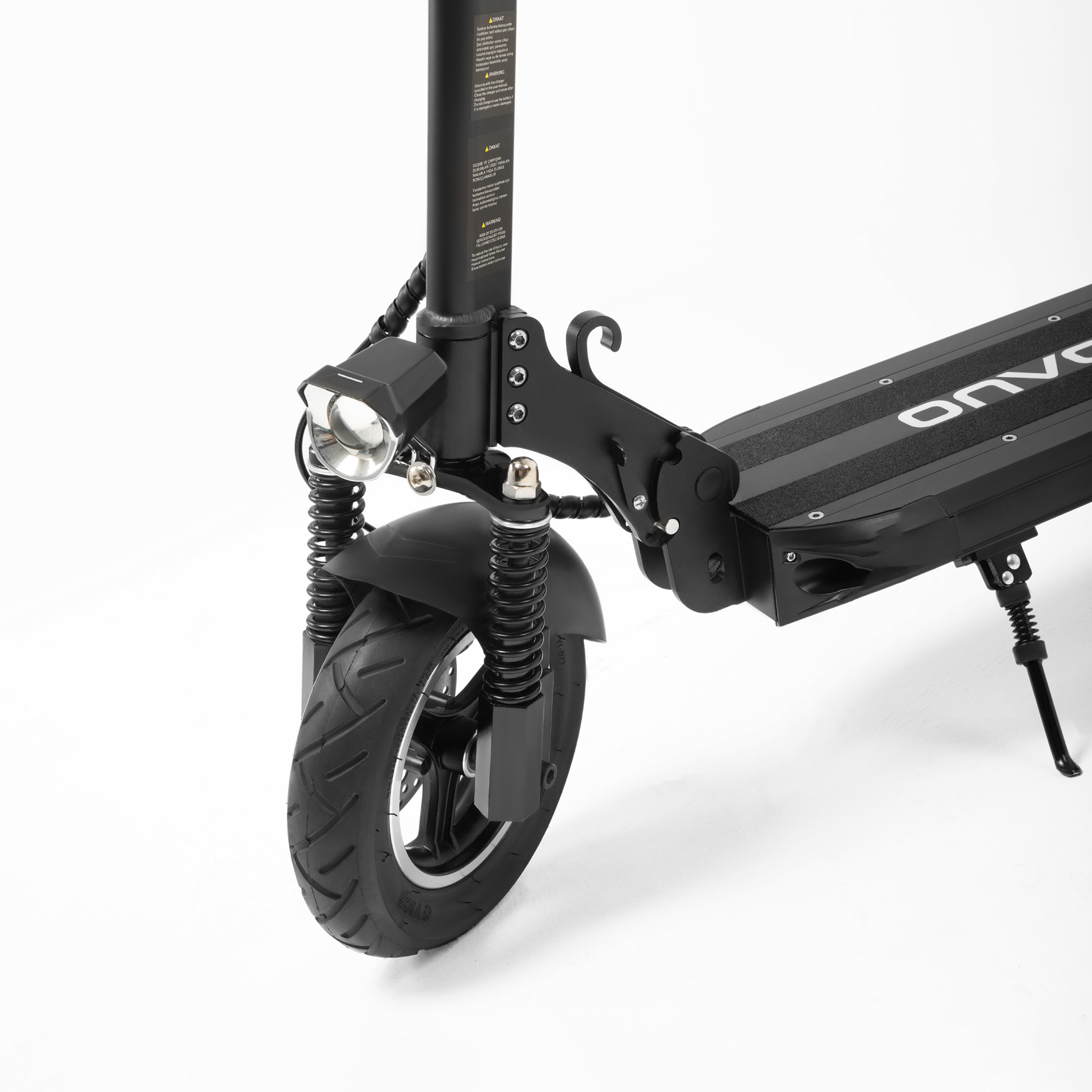Siyah bir elektrikli scooter'ın ön tekerleğinin ve süspansiyon sisteminin yakın çekimi.
