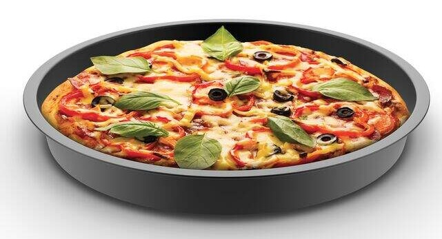 Pizza sötétszürke serpenyőben bazsalikomlevéllel. Feltétek: olajbogyó és paprika.