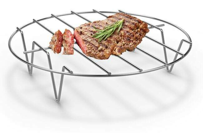 Grillezett steak rozmaringgal egy kerek fémrácson.