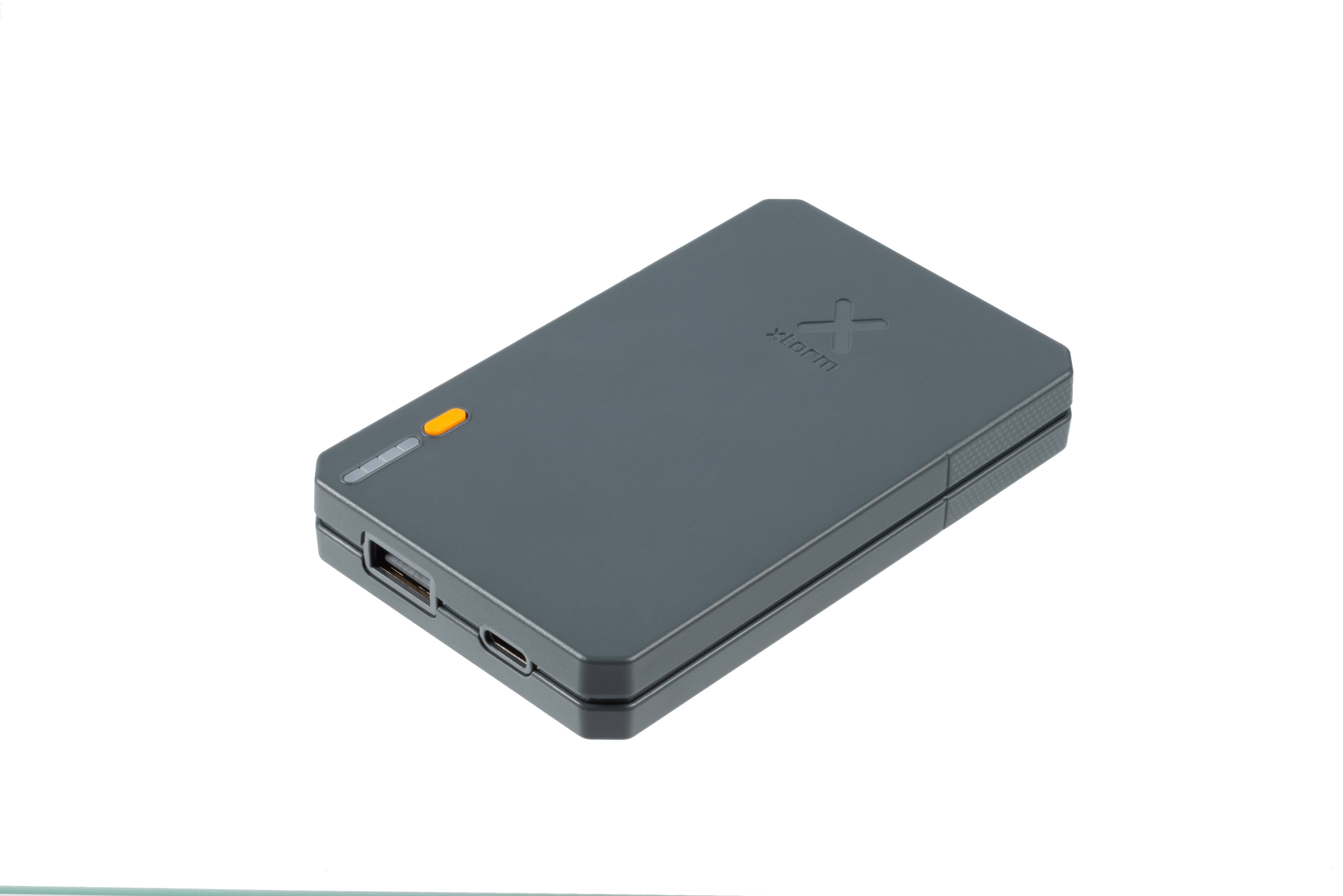 Eine graue, rechteckige Powerbank auf weißer Oberfläche. Sie hat eine orangefarbene Kontrollleuchte.