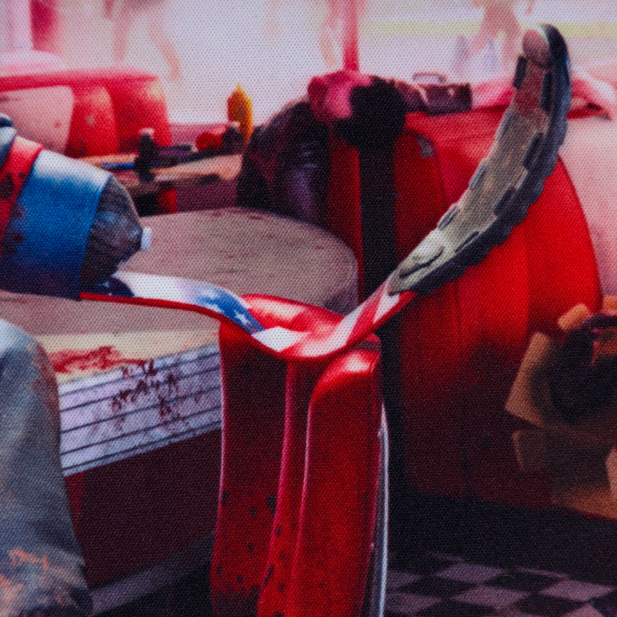 Nahaufnahme einer rot-weißen Diner-Kabine mit Säge auf farbenfroher, gemusterter Oberfläche.