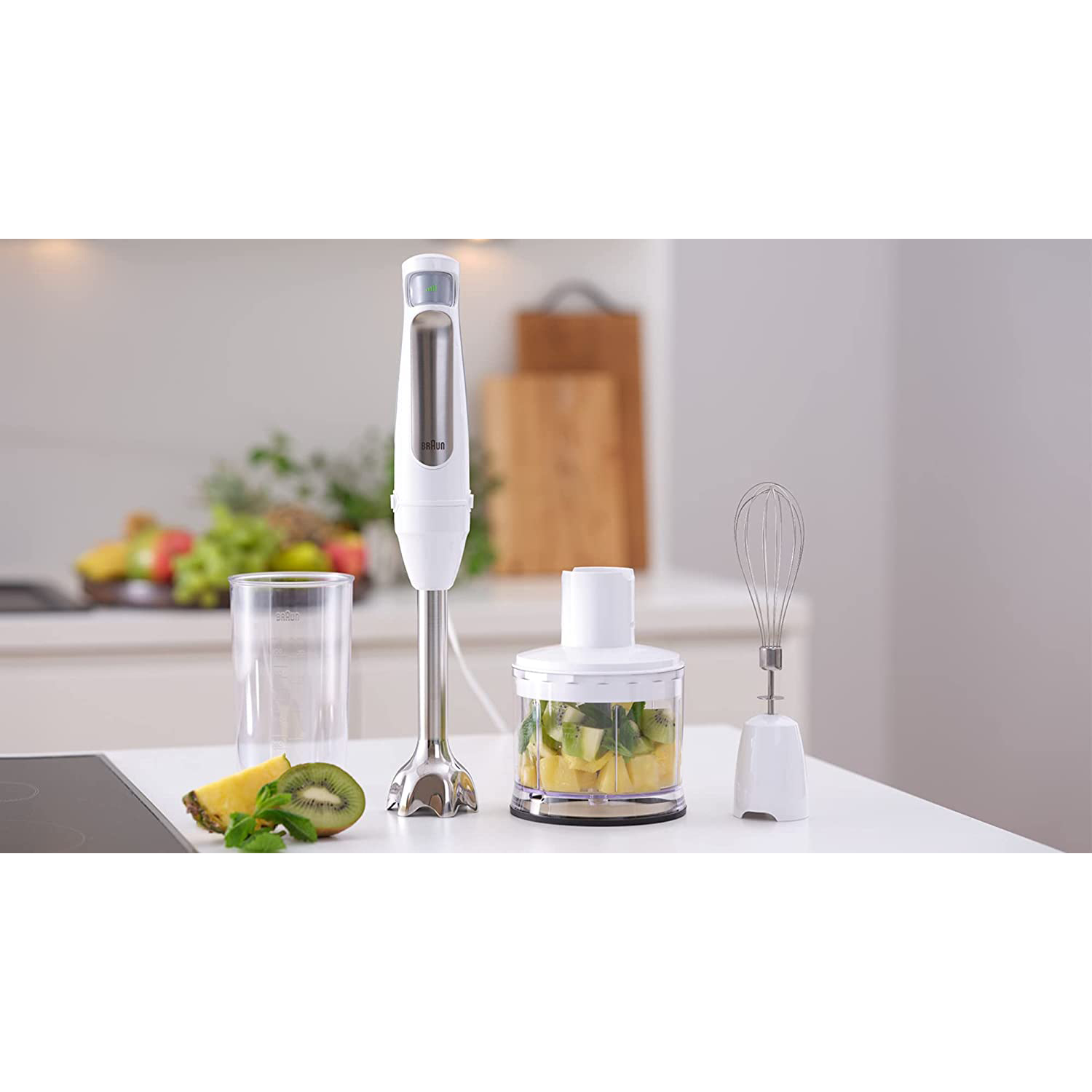 Un set di frullatore con vari accessori e ingredienti su una superficie bianca.