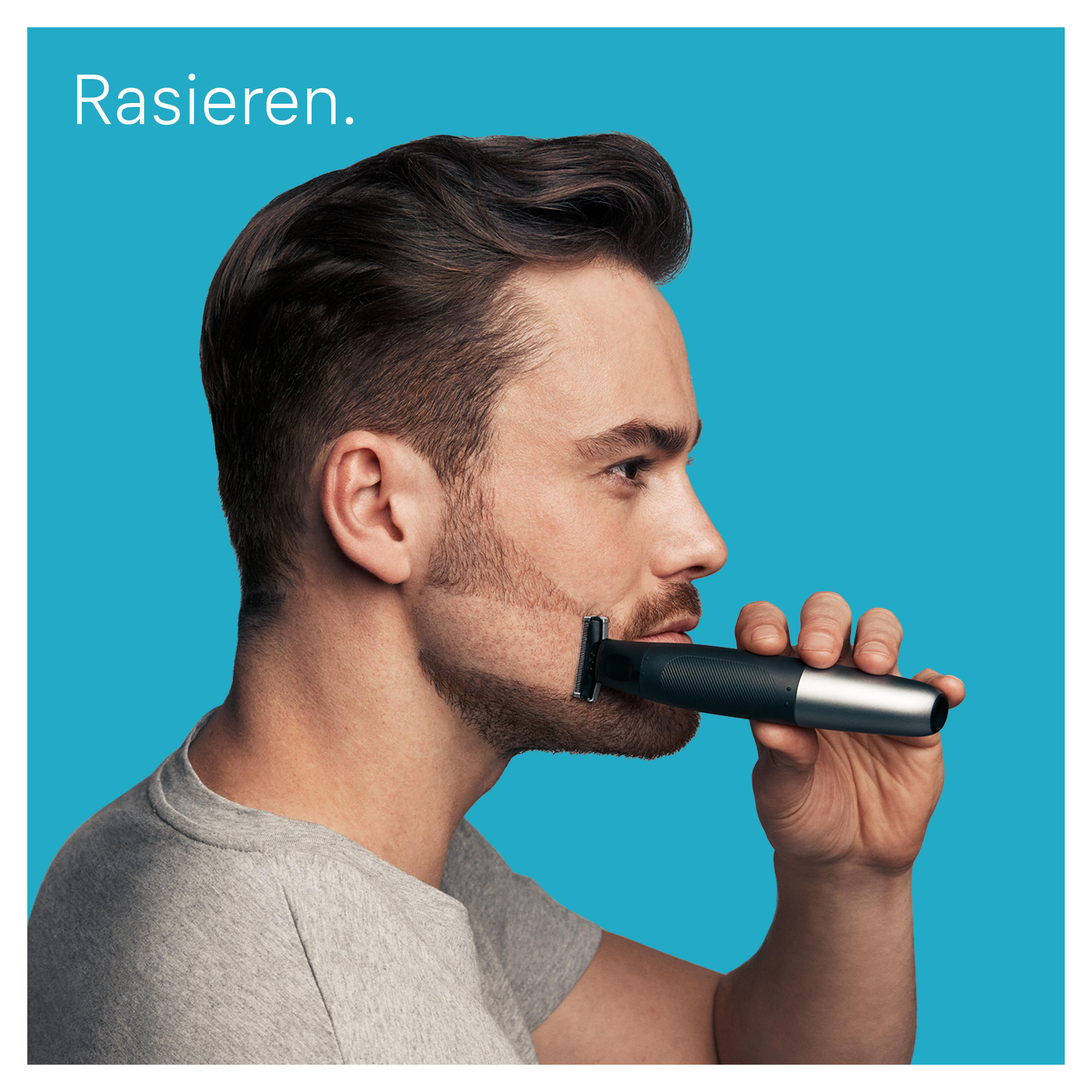 Ein Mann rasiert seinen Bart mit einem elektrischen Rasierer vor blauem Hintergrund.