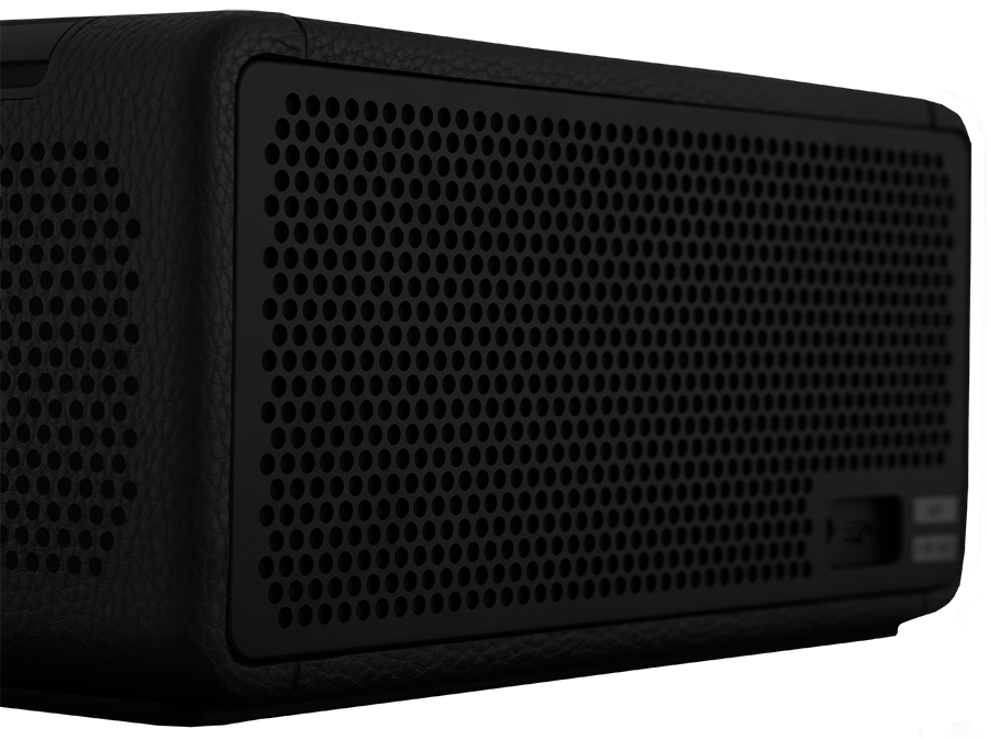 Black audio speaker with a perforated front and a side panel.