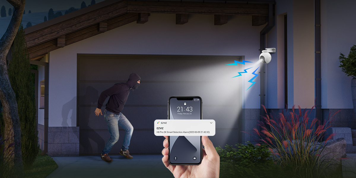 Une personne tenant un téléphone, avec une vue de caméra de sécurité et une notification d'un cambrioleur.