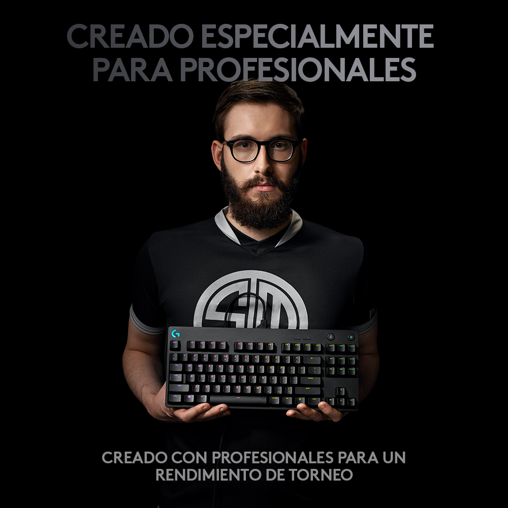 Un hombre sostiene un teclado negro con teclas coloridas. El texto dice "Creado para profesionales".