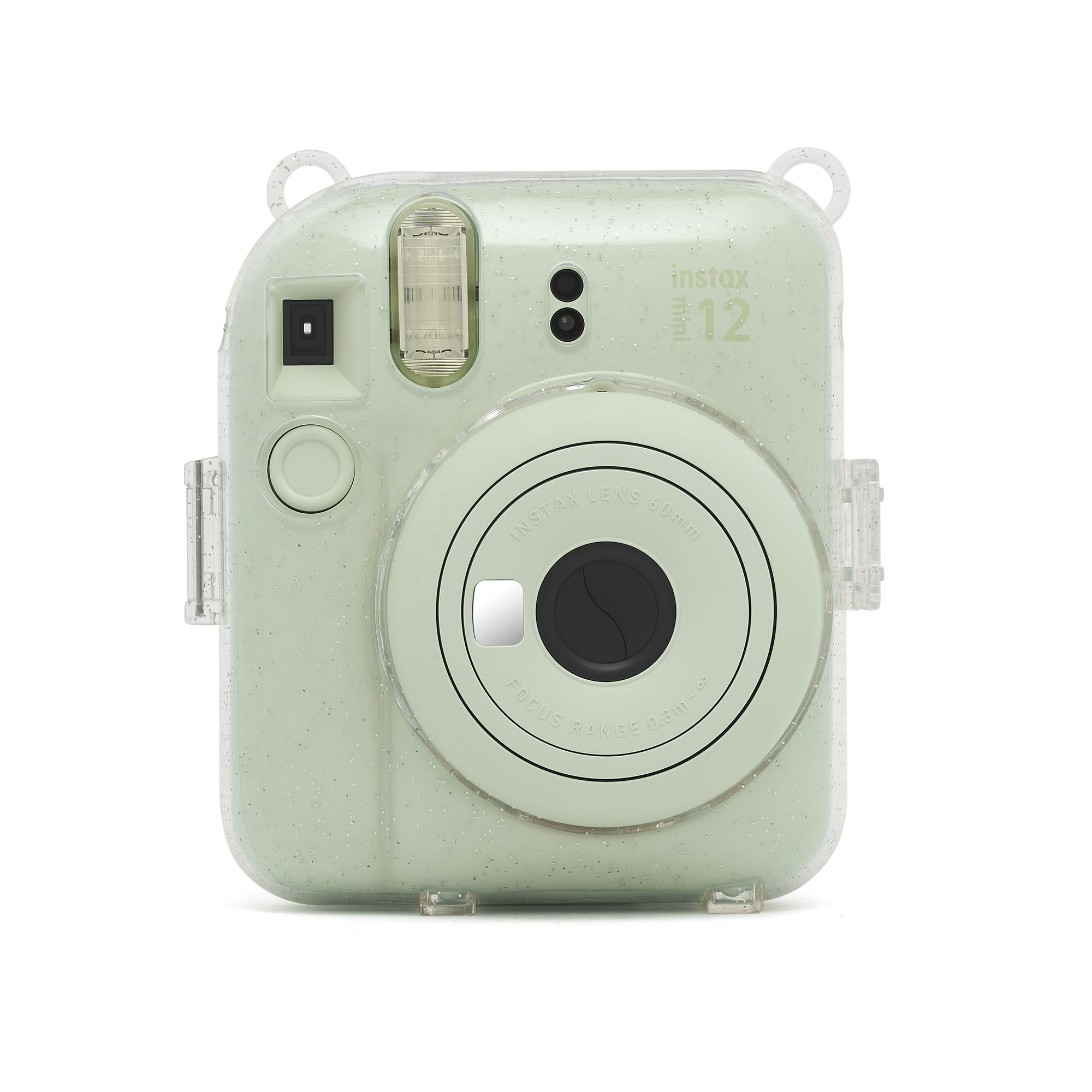Eine grüne Instax-Kamera mit durchsichtiger Hülle. Die Kamera hat ein schwarzes Objektiv.