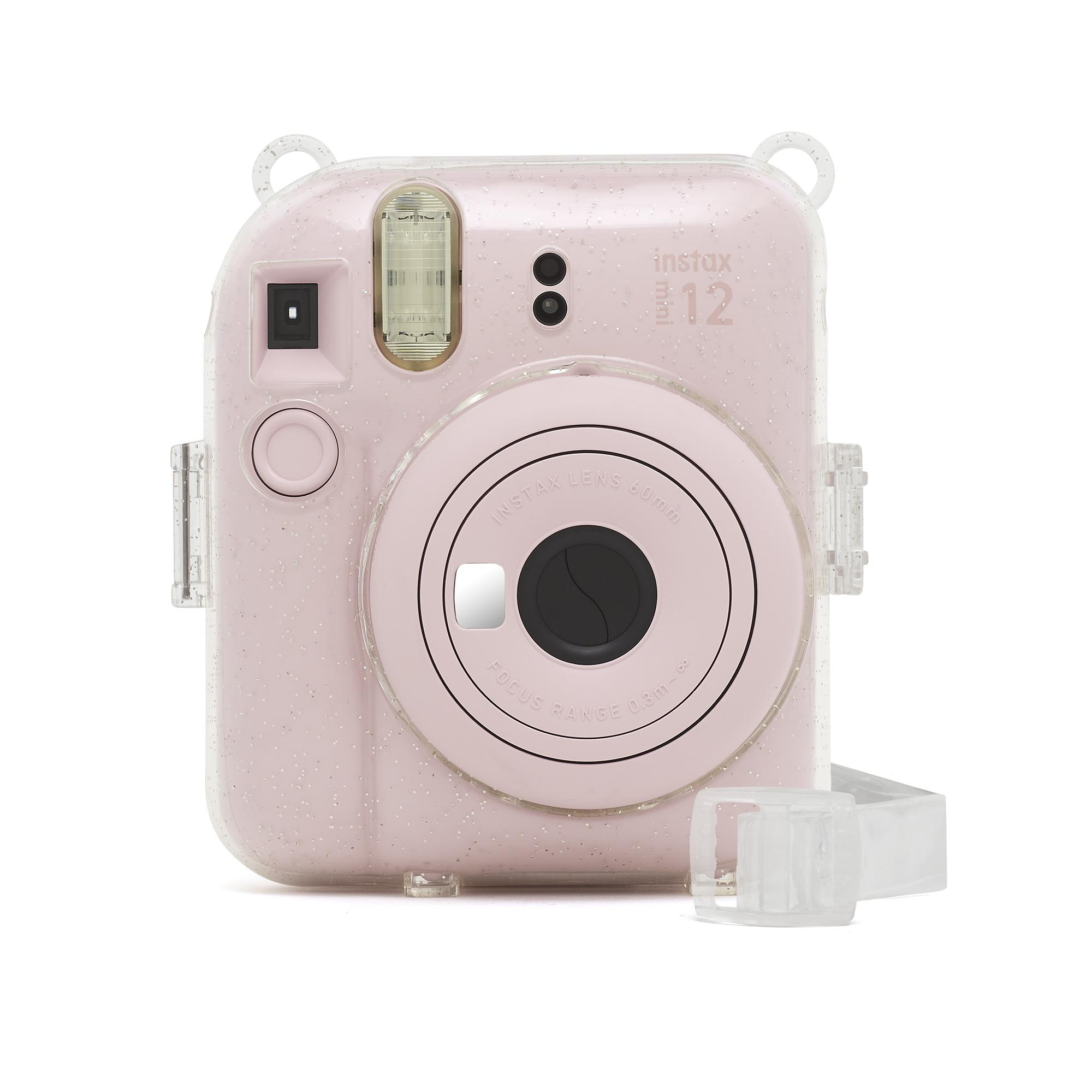 Rosa Instax-Kamera mit durchsichtigem Gehäuse. Transparenter Riemen ist befestigt. Weißer Hintergrund.