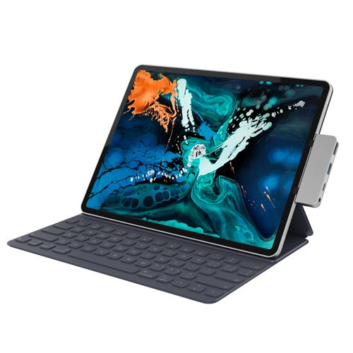 Una tableta con un teclado adjunto está sobre una superficie blanca. Hay un bolígrafo adjunto.